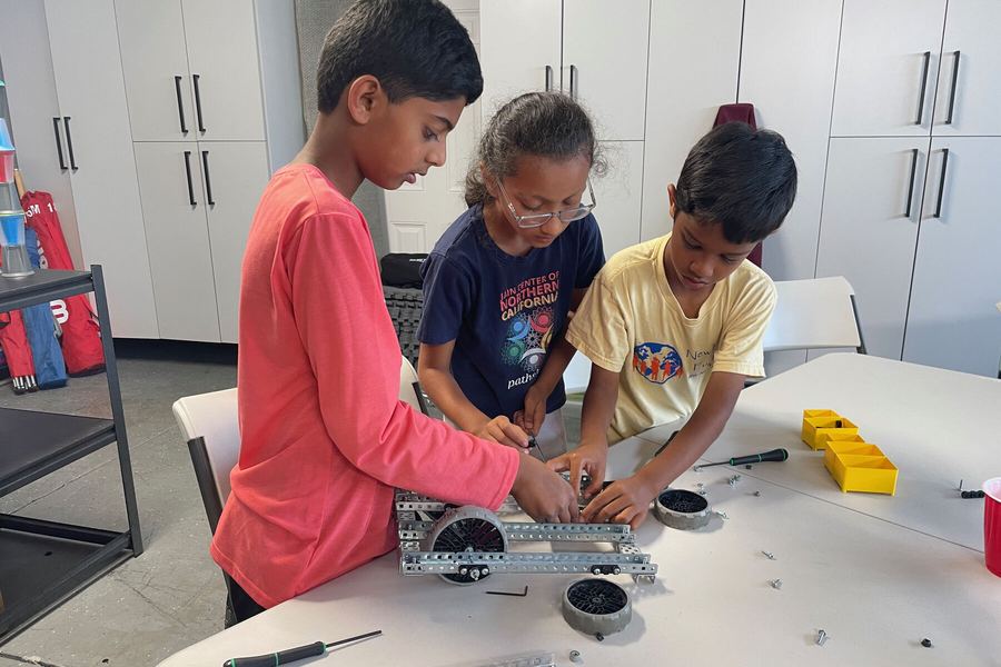 A camper assembling a robot chassis at the Rogue Robotics summer camp