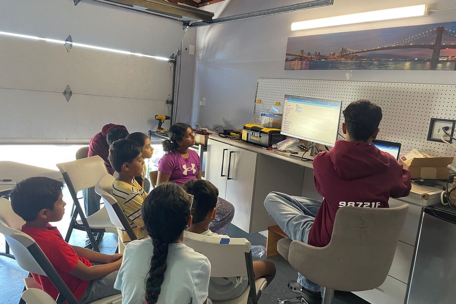 A team member helping campers wire motors to a brain